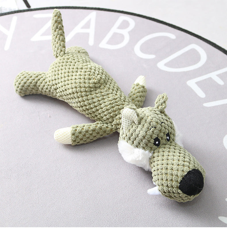 Crocheted green dog toy on a light gray surface 