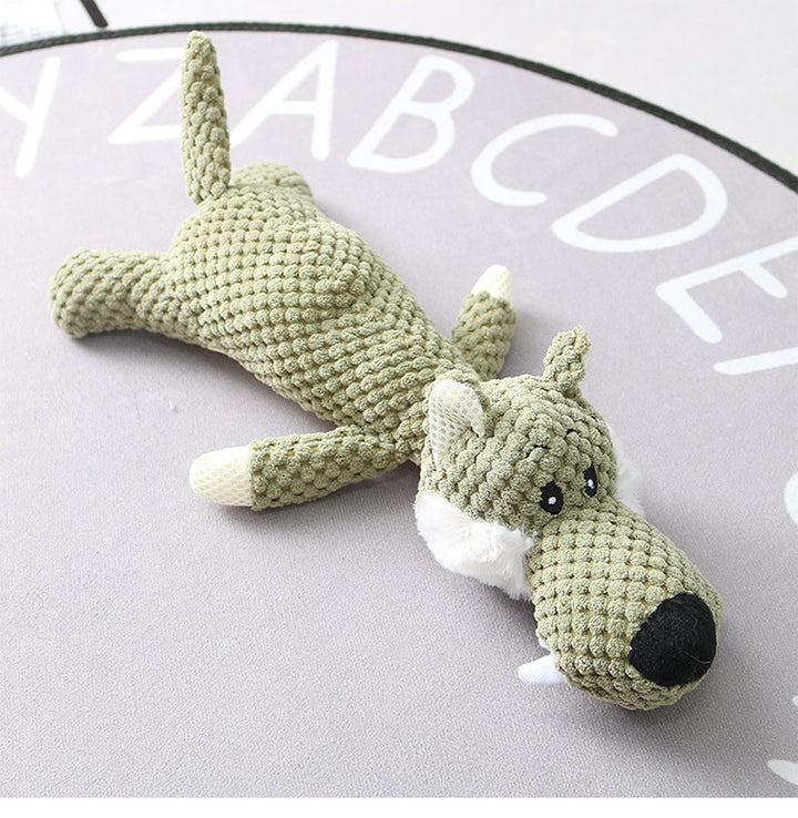 Crocheted green dog toy on a light gray surface 
