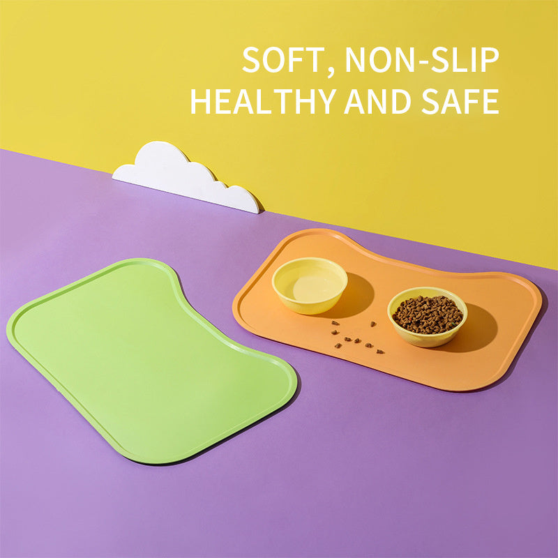 Green and orange pet mats with bowls on a purple surface