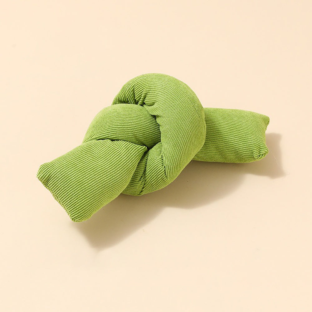 Green knotted pillow on a beige