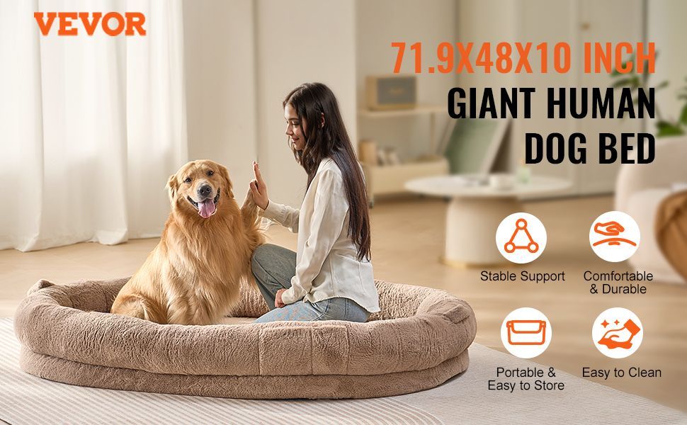 Woman sitting on a large dog bed with a dog