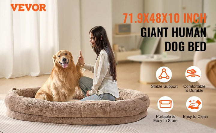 Woman sitting on a large dog bed with a dog
