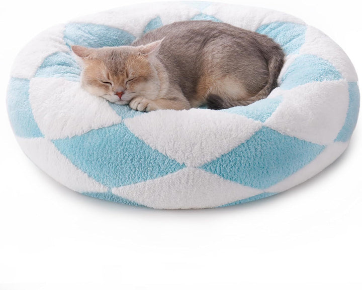 Cat sleeping on a blue and white patterned pet bed
