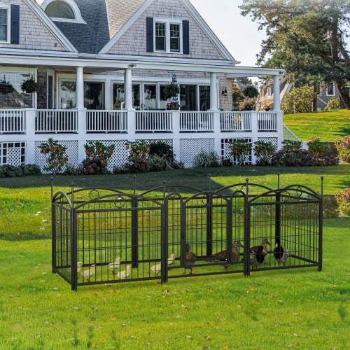 Large metal pet pen with ducks on a grassy lawn